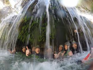 foto divertida de un grupo debajo de una cascada riendo y disfrutando